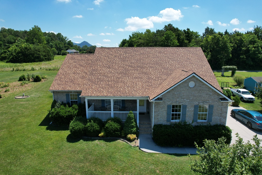 Roof Replacement In Corryton, TN Finished Front View Roof replacement in Corryton, TN with a finished front view of the new asphalt shingle roof.