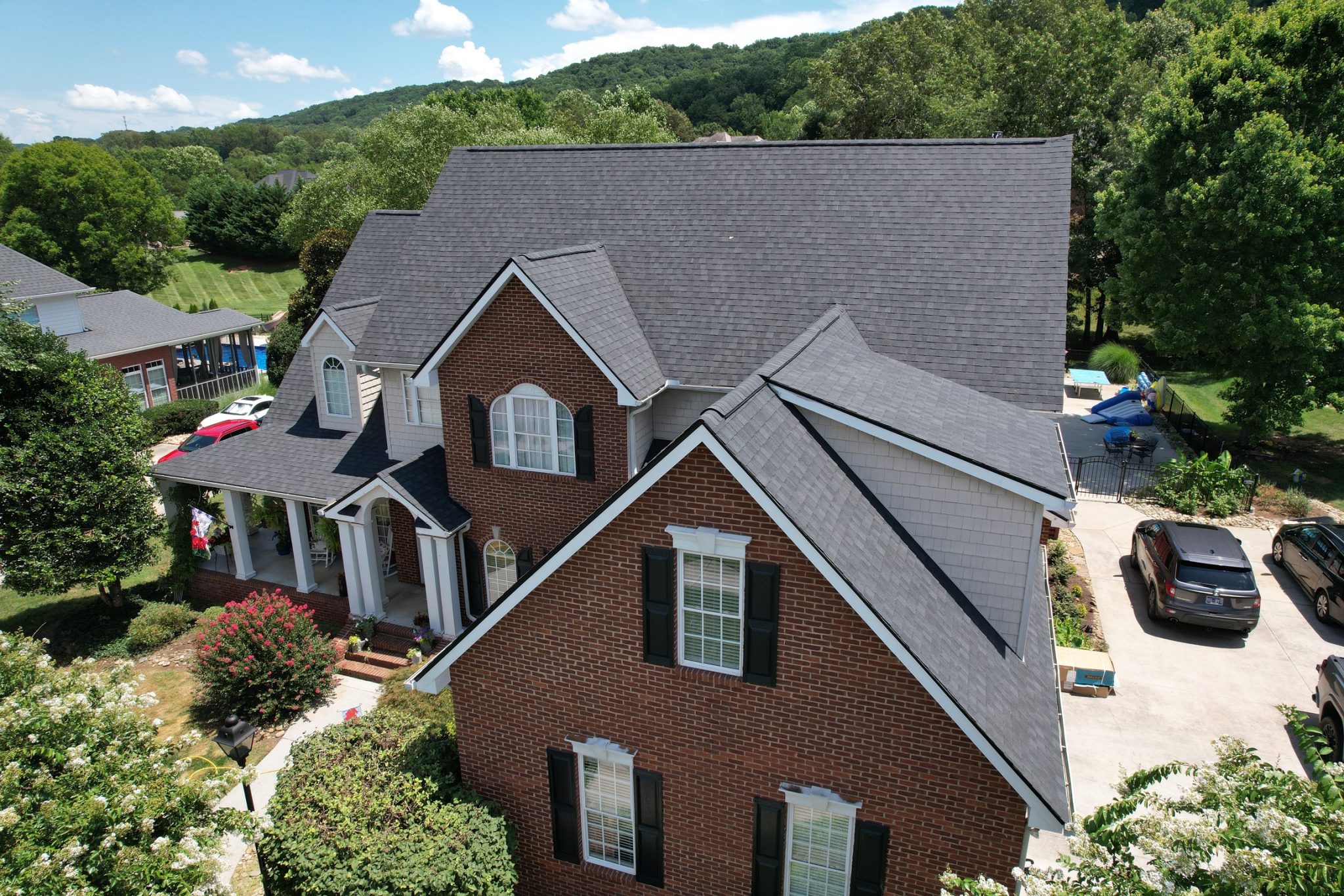 Aerial view of a Knoxville brick home with gray architectural asphalt shingles and clean ridge lines.