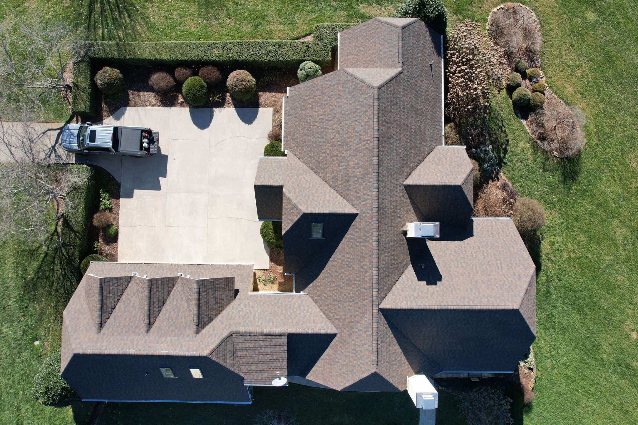 Drone view of a Knoxville roofline with multiple pitches and valleys, showing runoff paths that affect gutter performance.