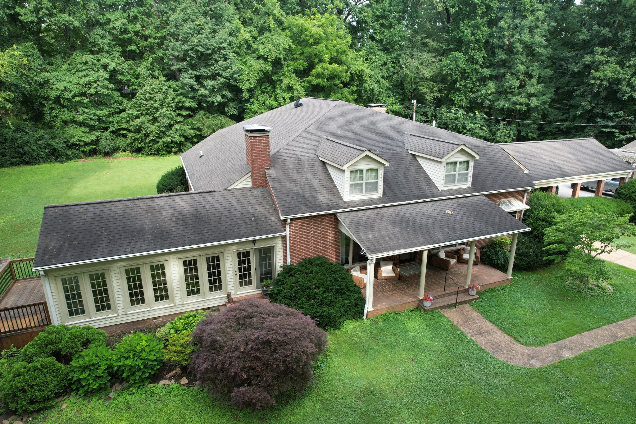 Maryville Roof Replacement Before New Shingles and Flashing Before photo of a Maryville roof replacement showing aging shingles, dark streaks, and worn flashing around a brick chimney.