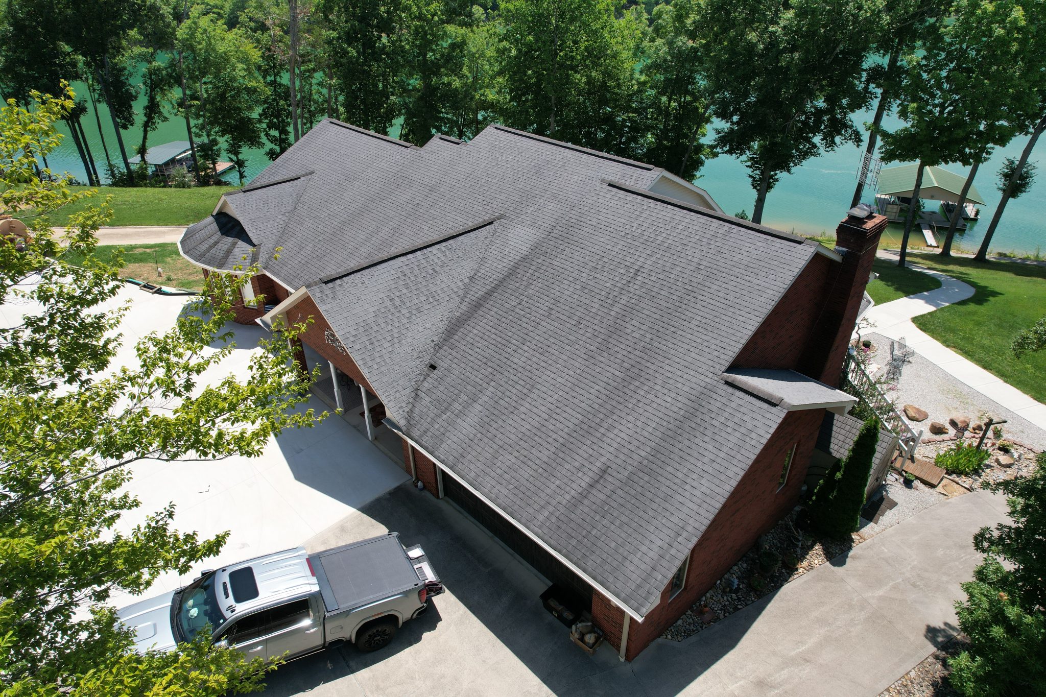 Before the Sharps Chapel Roof and Gutter Replacement Aging and patched roof before the Sharps Chapel roof and gutter replacement on a Norris Lake home.
