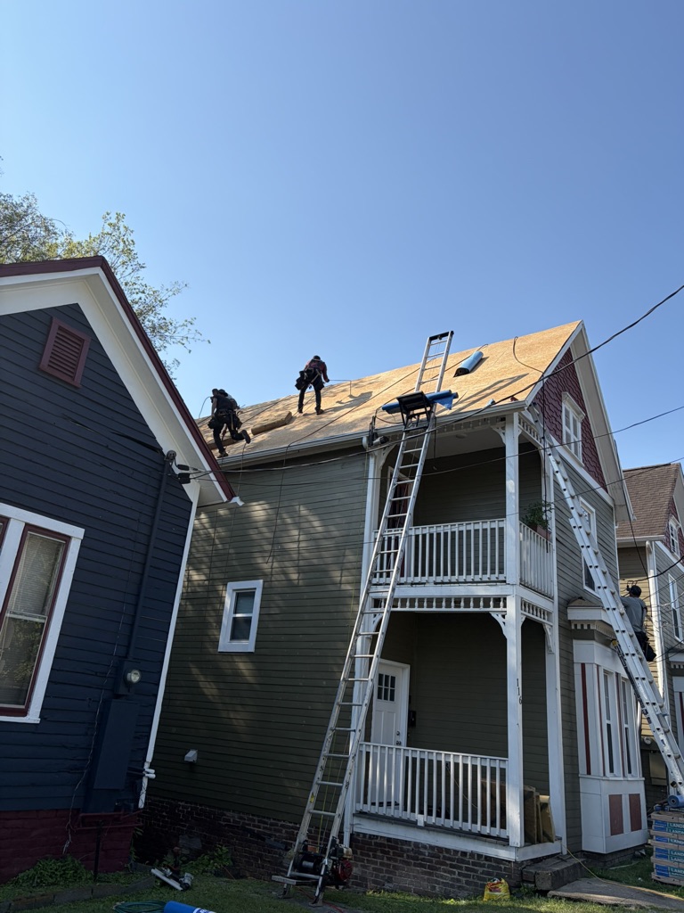 OSB Sheathing Installation On A Downtown Knoxville Roof Roofing crew installing full OSB sheathing on a Downtown Knoxville roof before new shingles are added.