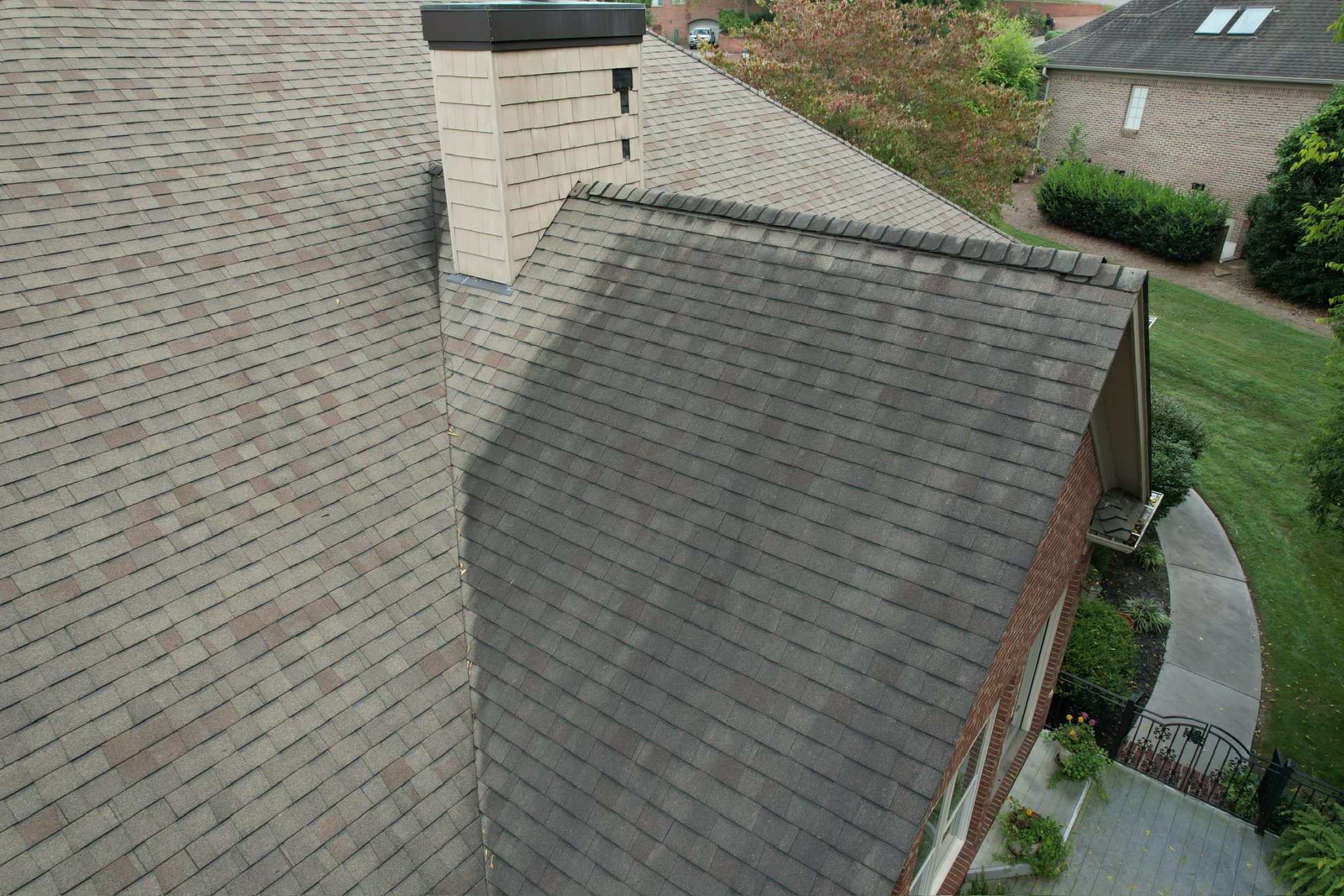 Roof inspection in East Tennessee Roof inspection in East Tennessee aerial view of an asphalt shingle roof with dark streaks near a valley and chimney.