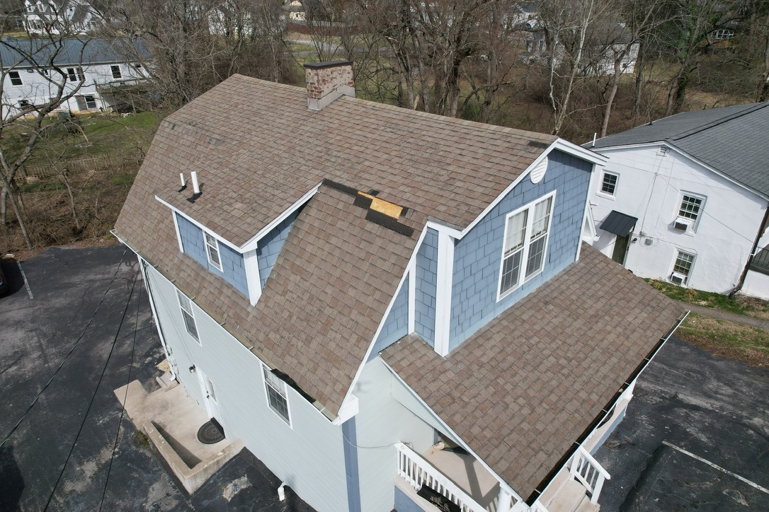 Broken roof in Fountain City project before replacement, showing missing shingles and exposed roof decking.