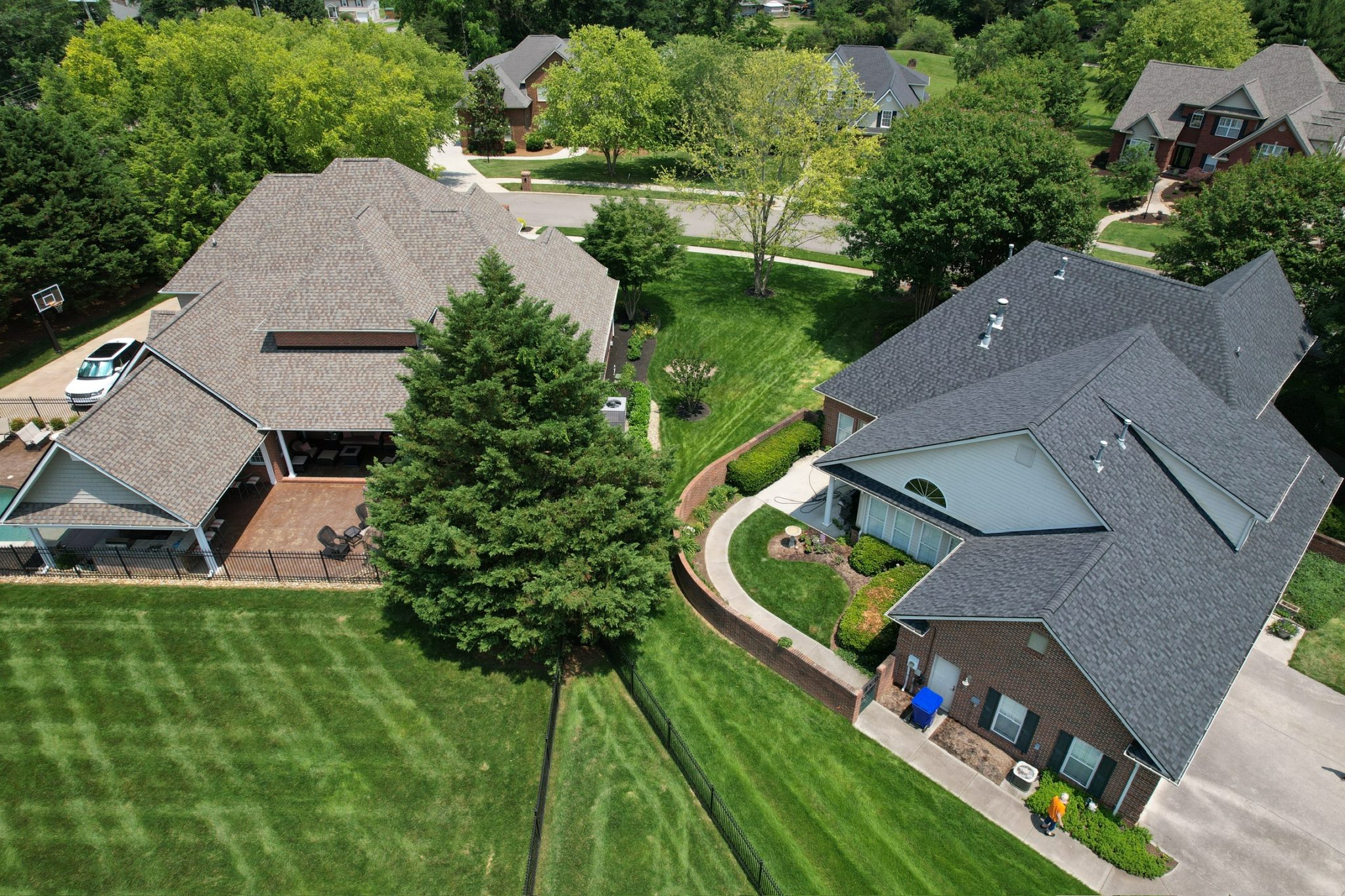 Aerial View of Two Newly Installed Asphalt Roofs in East Tennessee This drone photo highlights two freshly installed asphalt roofs, showcasing clean lines and quality workmanship from trusted roof replacement contractors in East Tennessee.