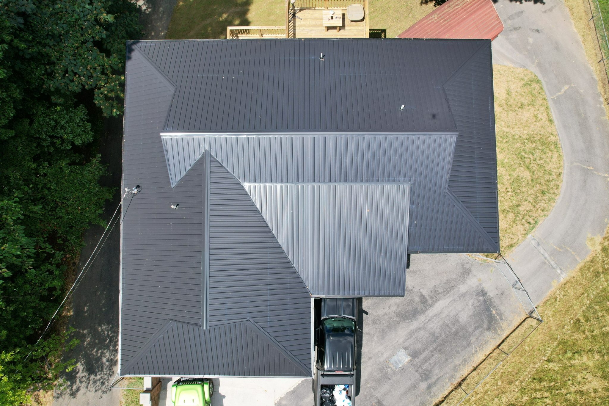 Completed Roof Installation by a Trusted Roofing Contractor Overhead view of a new black metal roof installed by a roofing contractor